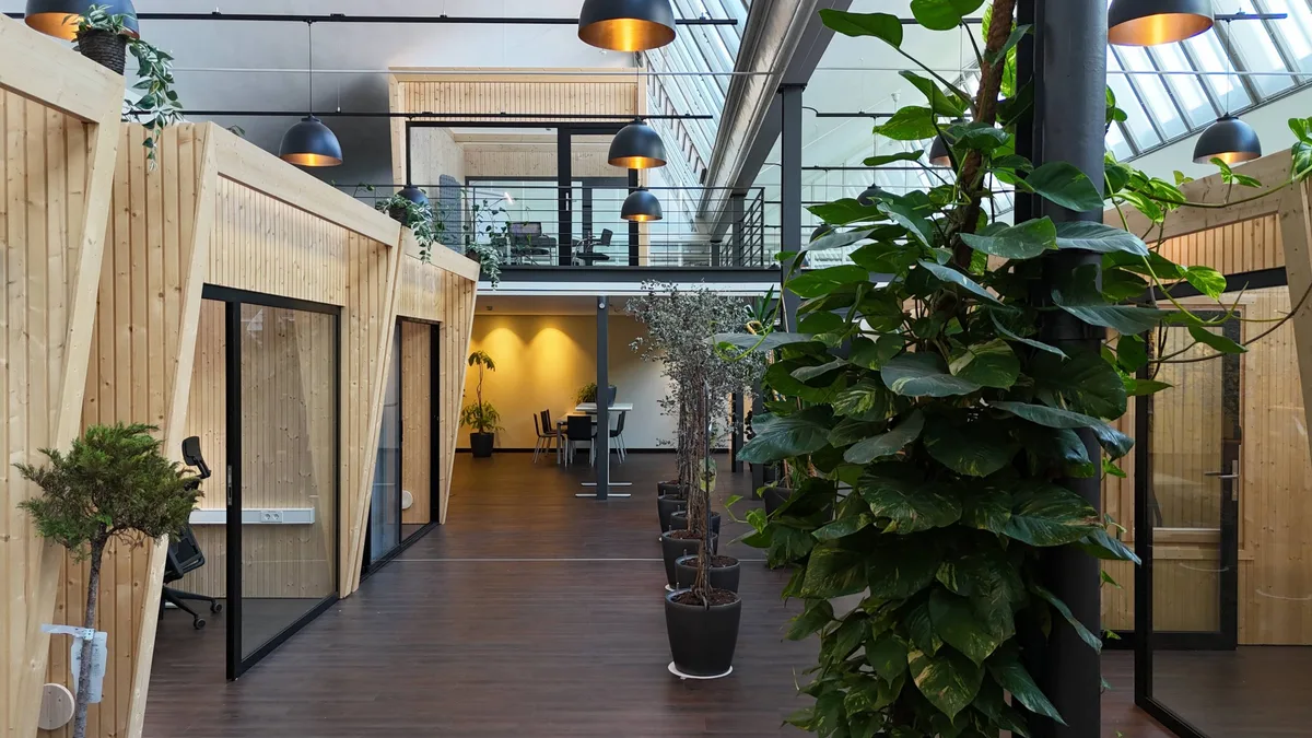 Heller Coworking-Bereich im Green Office des Partner-Business-Centers in Weil am Rhein, zwei Personen im Gespräch an einem Arbeitstisch